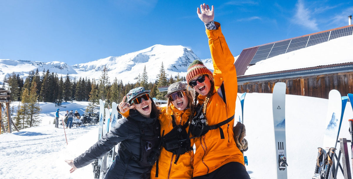 Three women enjoying spring skiing parties in the mountains while surrounded by Renoun skis