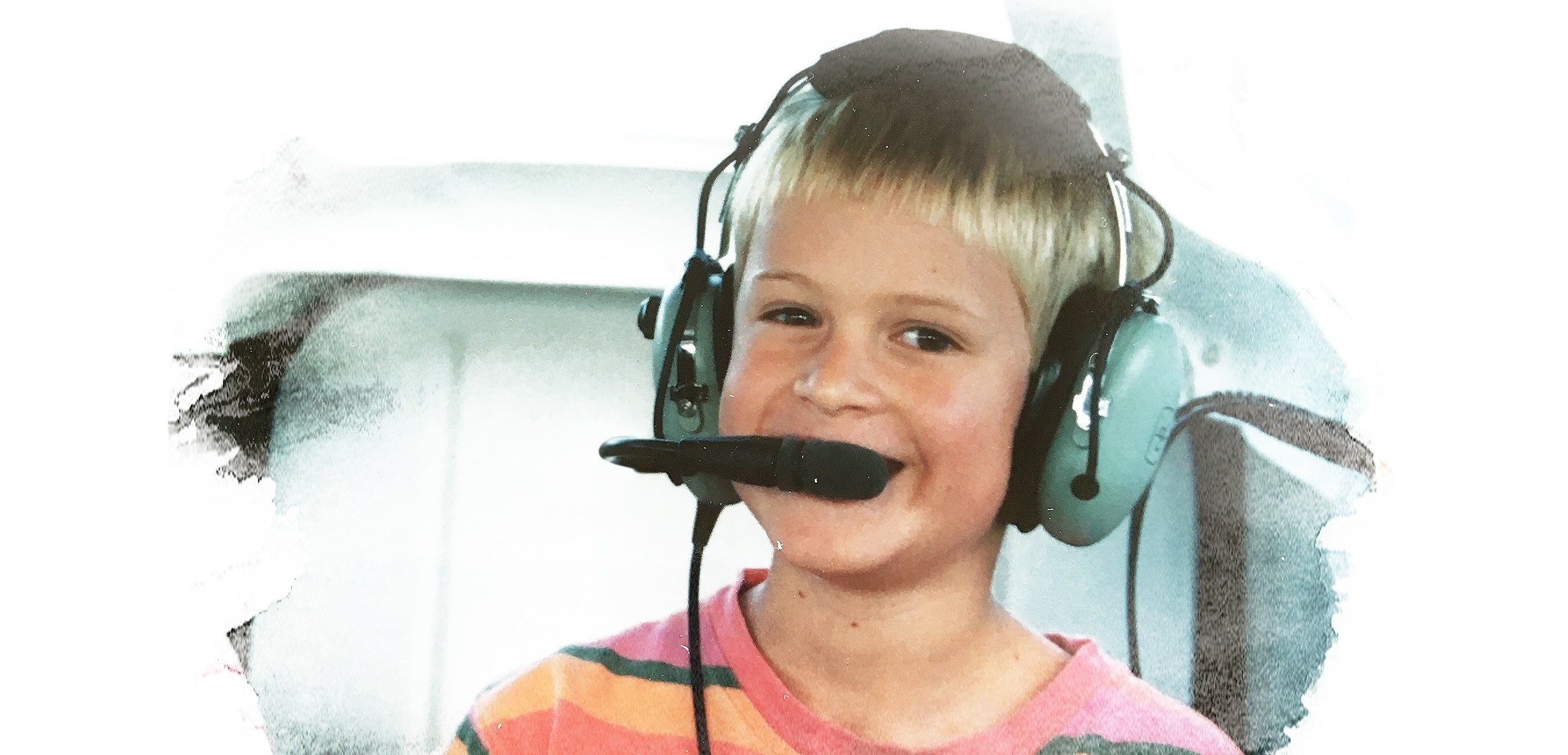 Cyrus as a kid in a plane wearing a headset