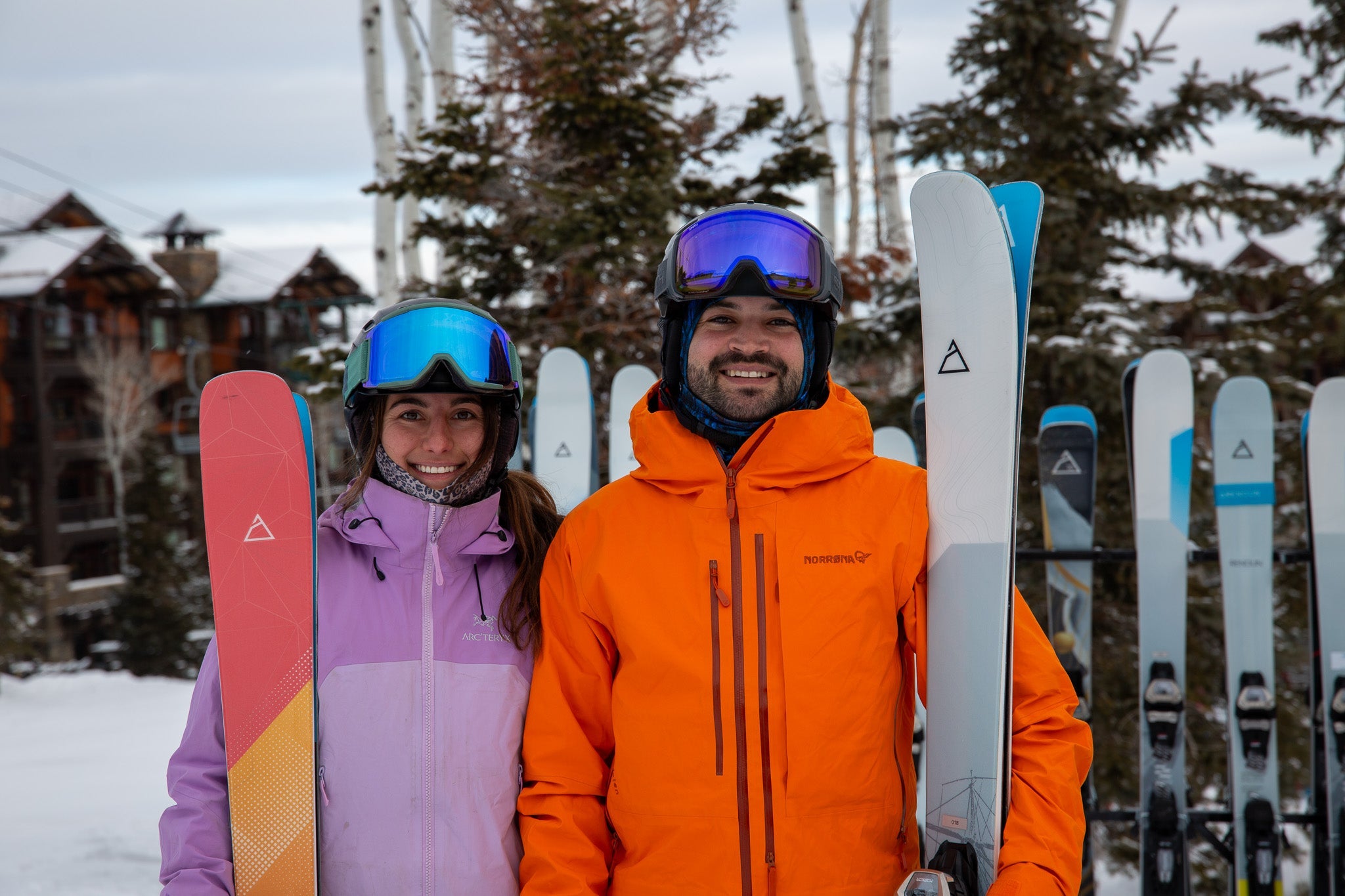 Skiing couple holding Renoun Endurance 98 and Earhart 88 skis